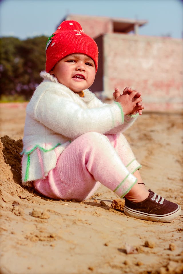 A young girl sitting on the sand