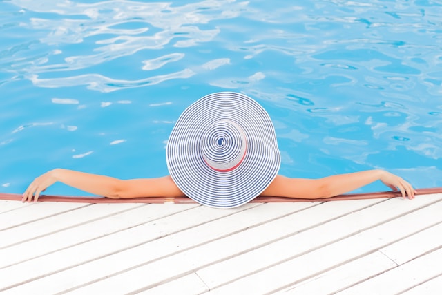 A woman in a hat enjoying a hot pool